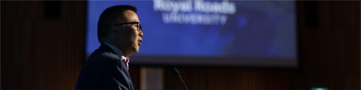 Nelson Chan speaking on stage at Royal Roads University